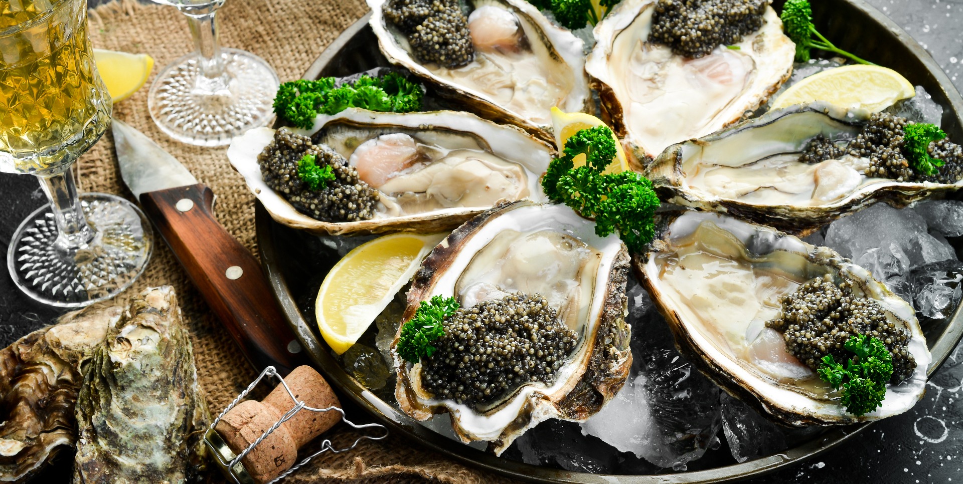 Frische Austern mit Zitronenkaviar und Eis. Restaurant-Delikatesse. Austerngericht. Ansicht von oben. Freier Kopierraum.