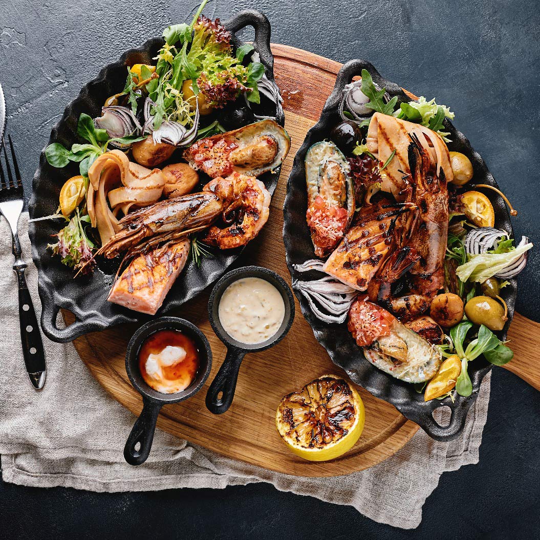 Eine abwechslungsreiche Auswahl von gegrilltem Meeresfrüchten auf buntem Salatbett